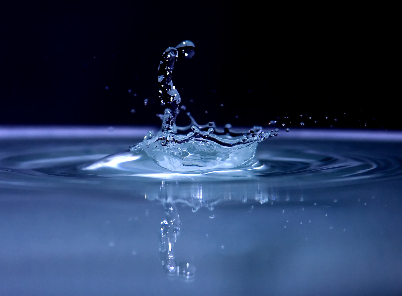 Photograph of water droplet hitting pool of water
